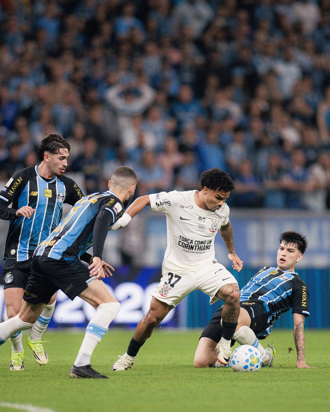 A imagem mostra Kaio César, do Corinthians, driblando jogadores do Grêmio