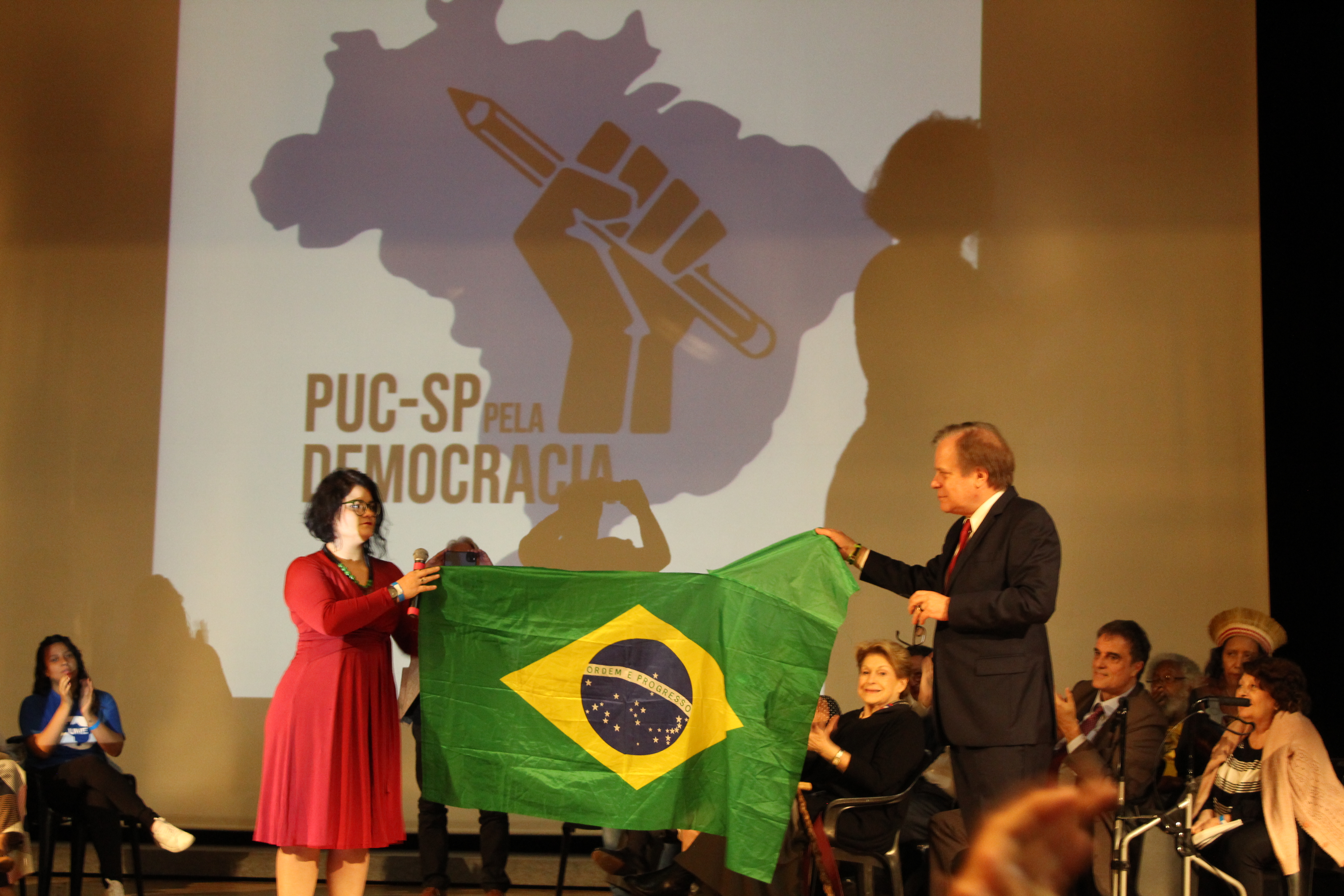 Cristiane Fairbanks, presidenta da APG (Associação dos Alunos de Pós-Graduação da PUC-SP), e o jornalista Chico Pinheiro seguravam bandeira do Brasil em ato em prol da democracia. Foto: Laura Mafra Boechat.