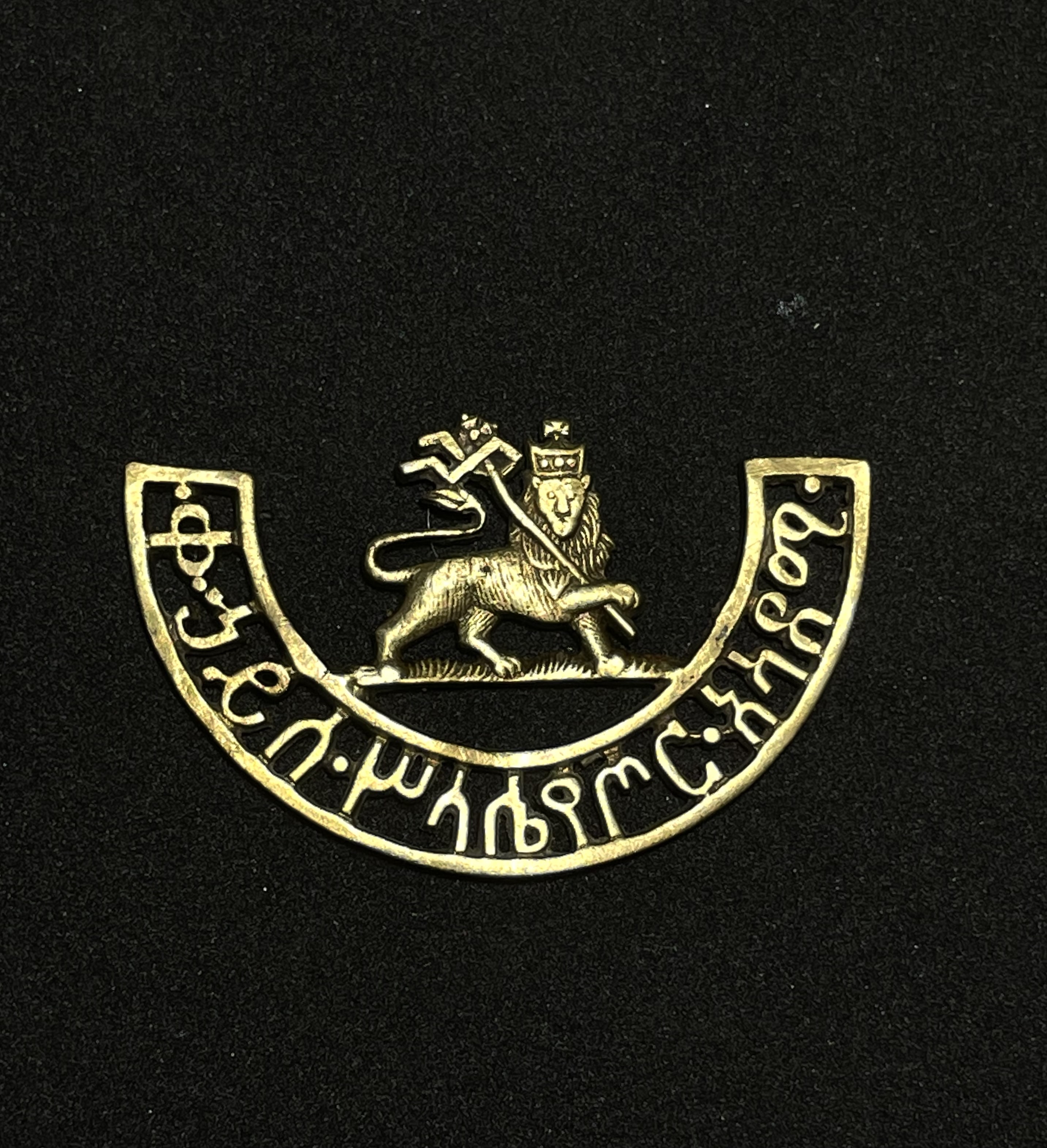 Distintivo utilizado pelos oficiais do exército imperial etíope. O broche é adornado com o icônico símbolo do Leão de Judá e traz uma inscrição em aramaico que traduz "Academia Militar Haile Selassie", (1919-1938). 