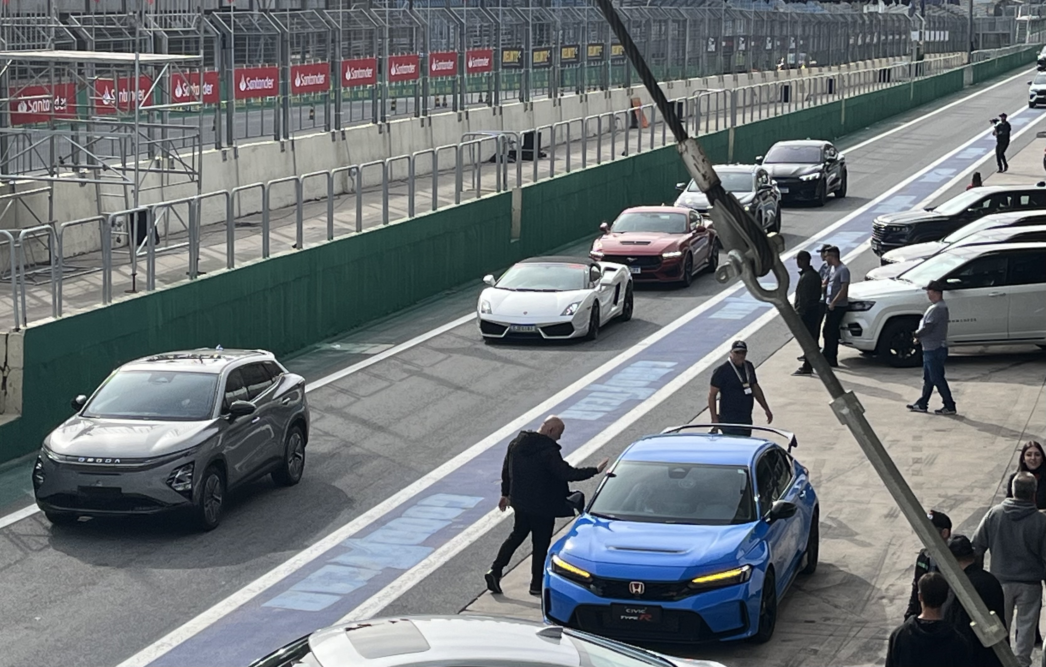 Vários carros na parte dos boxes na pista de Interlagos, como Honda Civic Type R, Omoda E5 e Ford Mustang