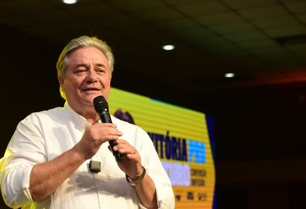 Candidato Luiz Paulo Vellozo Lucas em evento de campanha com microfone na mão