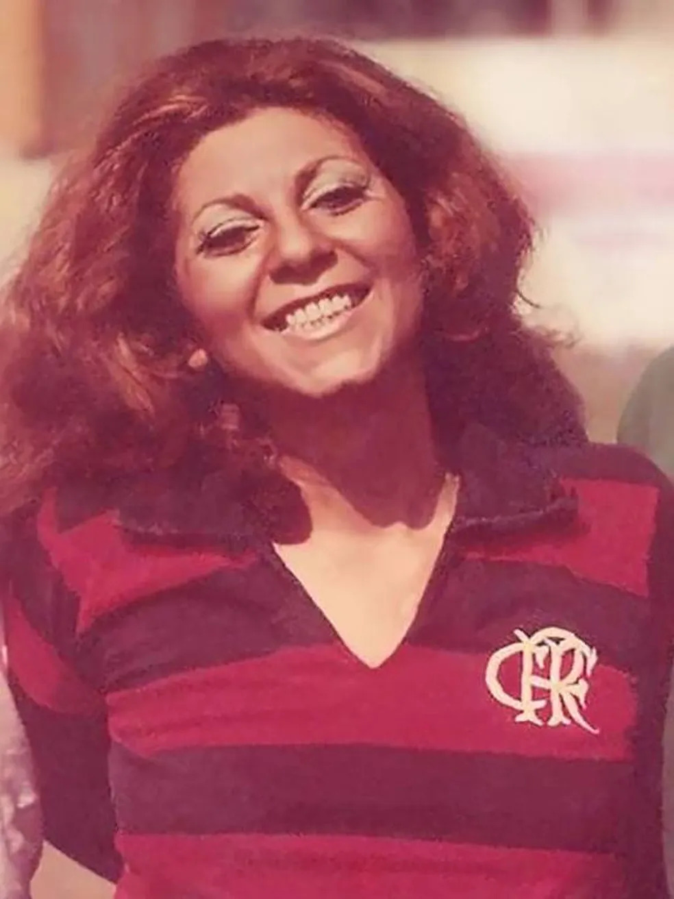 Mulher adulta sorrindo vestindo a camisa do Flamengo