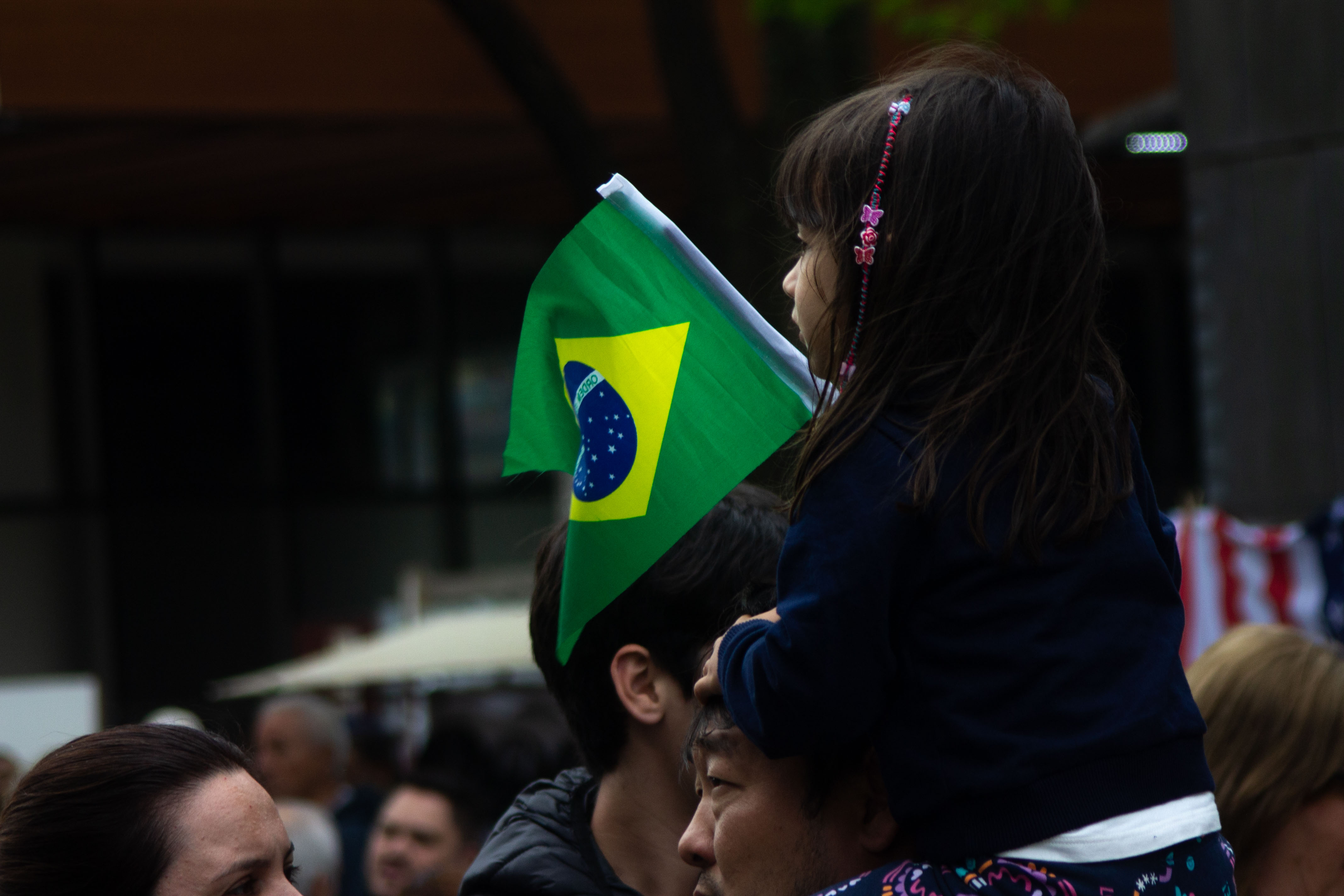 Uma criança em meio a manifestação que segurava e balançava sua bandeira em cima de seu pai / Foto: Rafael Pessoa