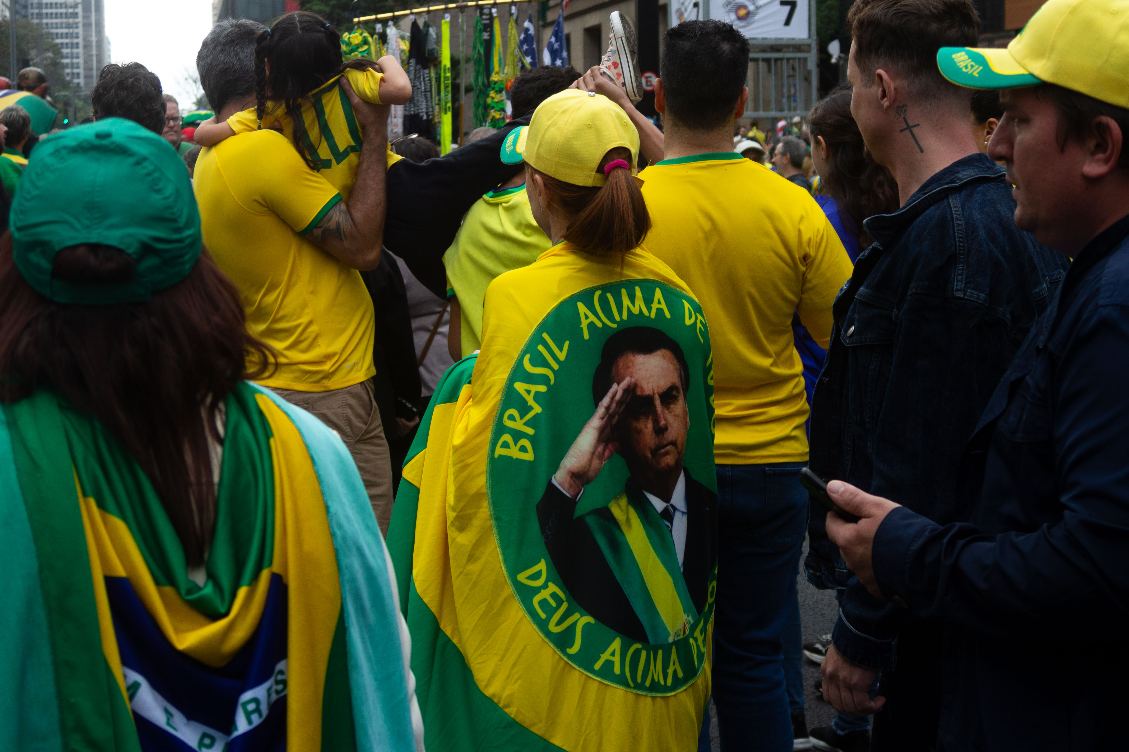 Manifestantes vestindo suas bandeiras e mais a frente um pai segurando sua filha / Foto: Rafael Pessoa