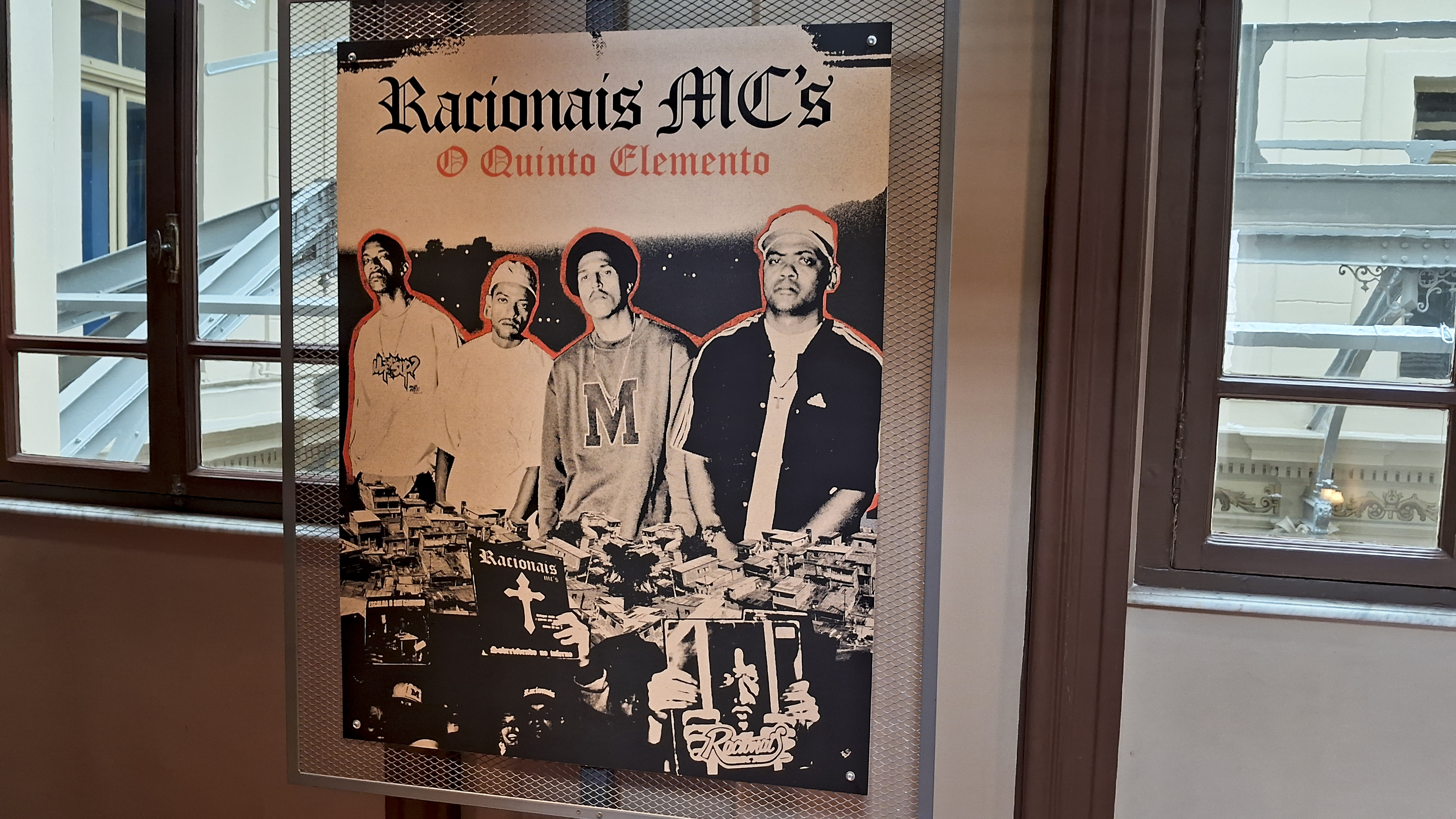A imagem mostra um painel os quatros membros dos Racionais MC's