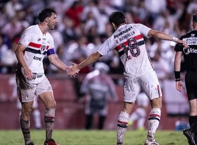 A imagem mostra os jogadores Calleri e Bobadilla, ambos do São Paulo, se cumprimentando. Ao fundo está a torcida.