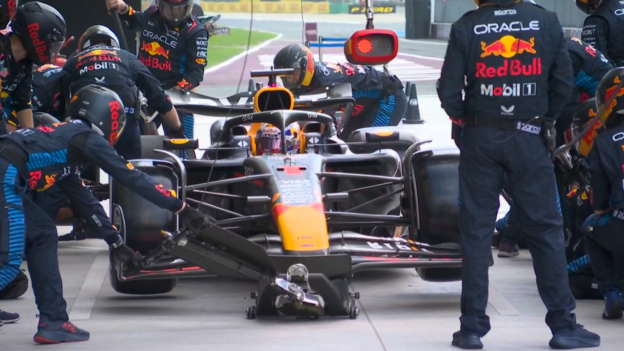 Mecânicos da Red Bull com problemas para tirar o pneu traseiro direito do carro de Max Verstappen. – Foto: Reprodução/F1TV