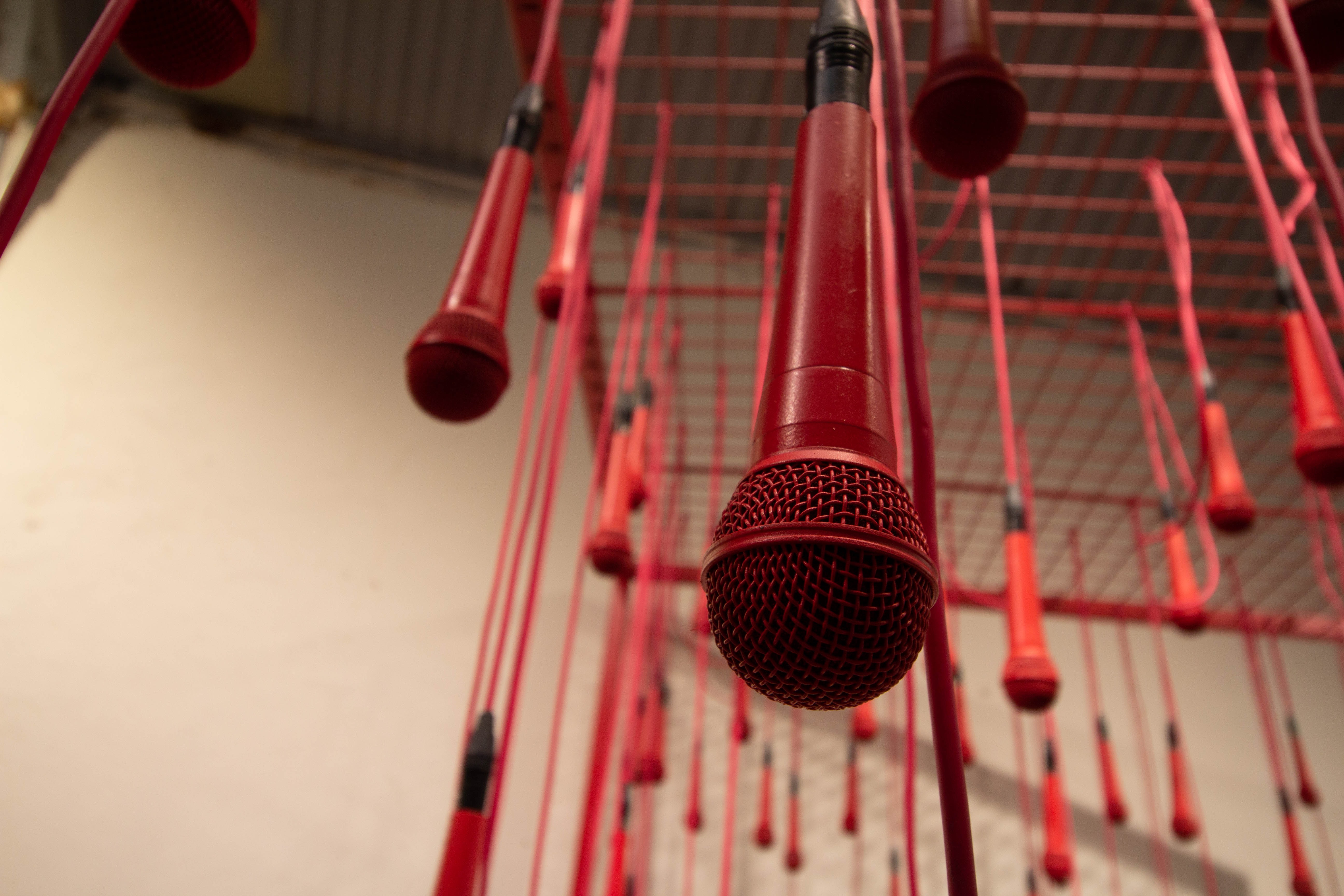 Microfones vermelhos pendurados em estrutura de ferro 