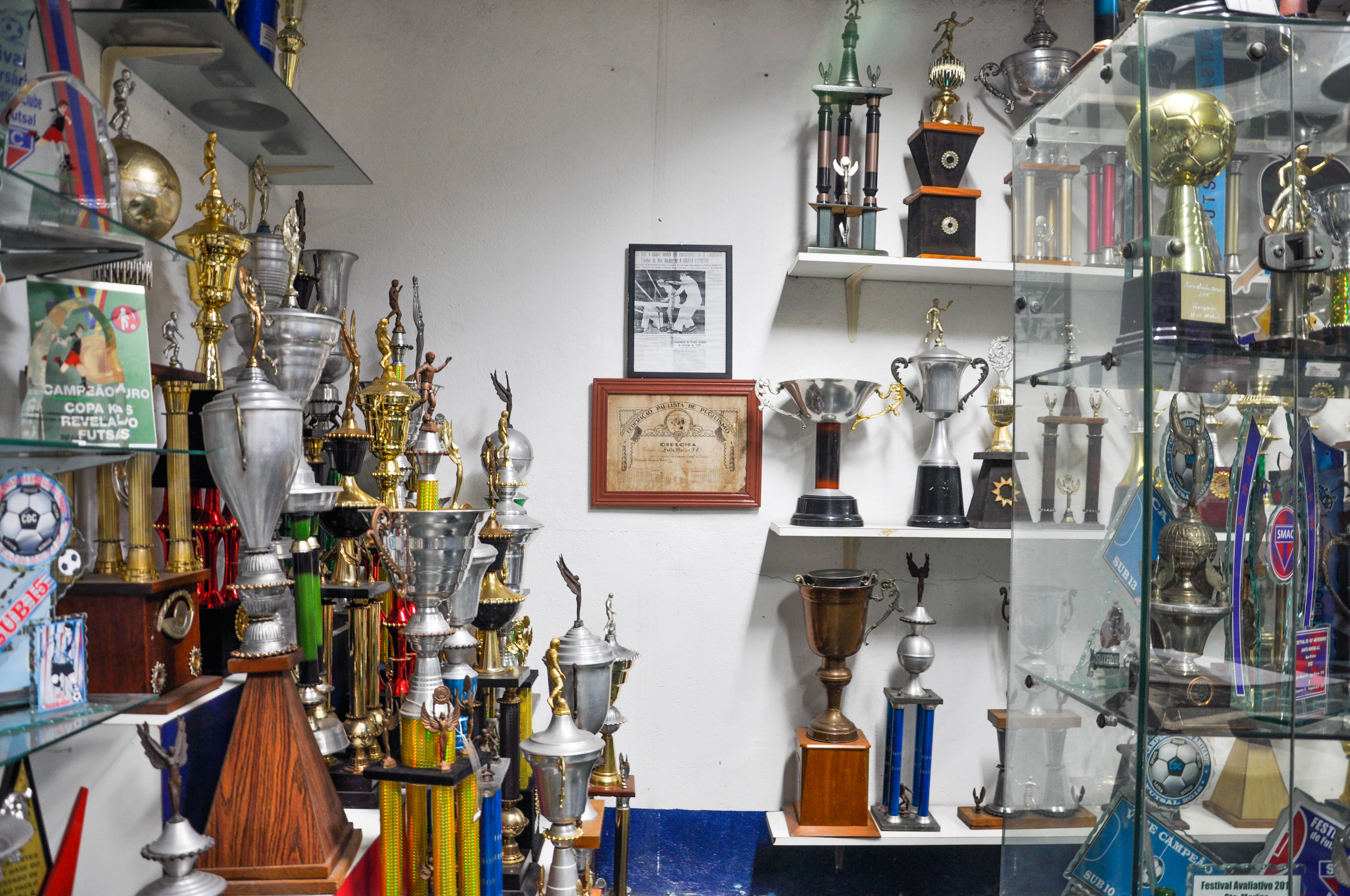 Acervo de fotos e troféus do Santa Marina Atlético Clube. A assessora Kelseny Medeiros, mães, jogadores e outros membros da comunidade SMAC discutem sobre a desocupação. Fotos por Bianca Abreu.