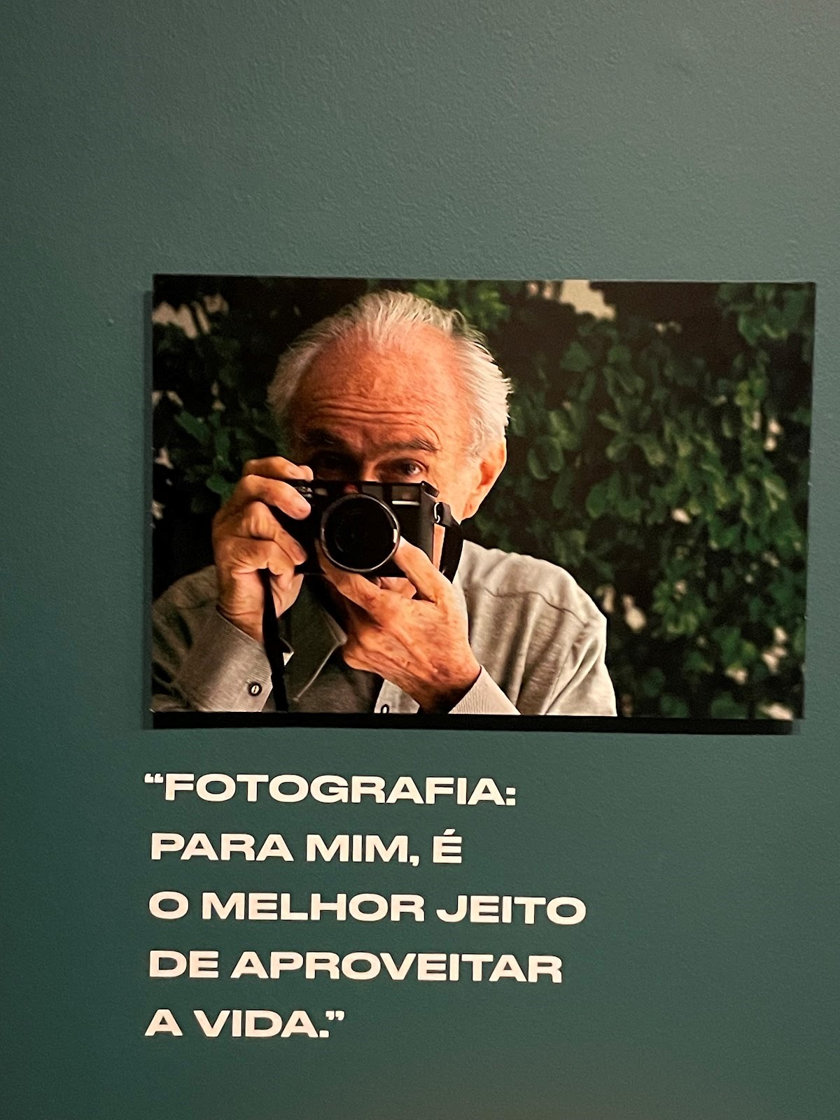 Fotógrafo Thomaz Farkas segurando uma câmera na mão 