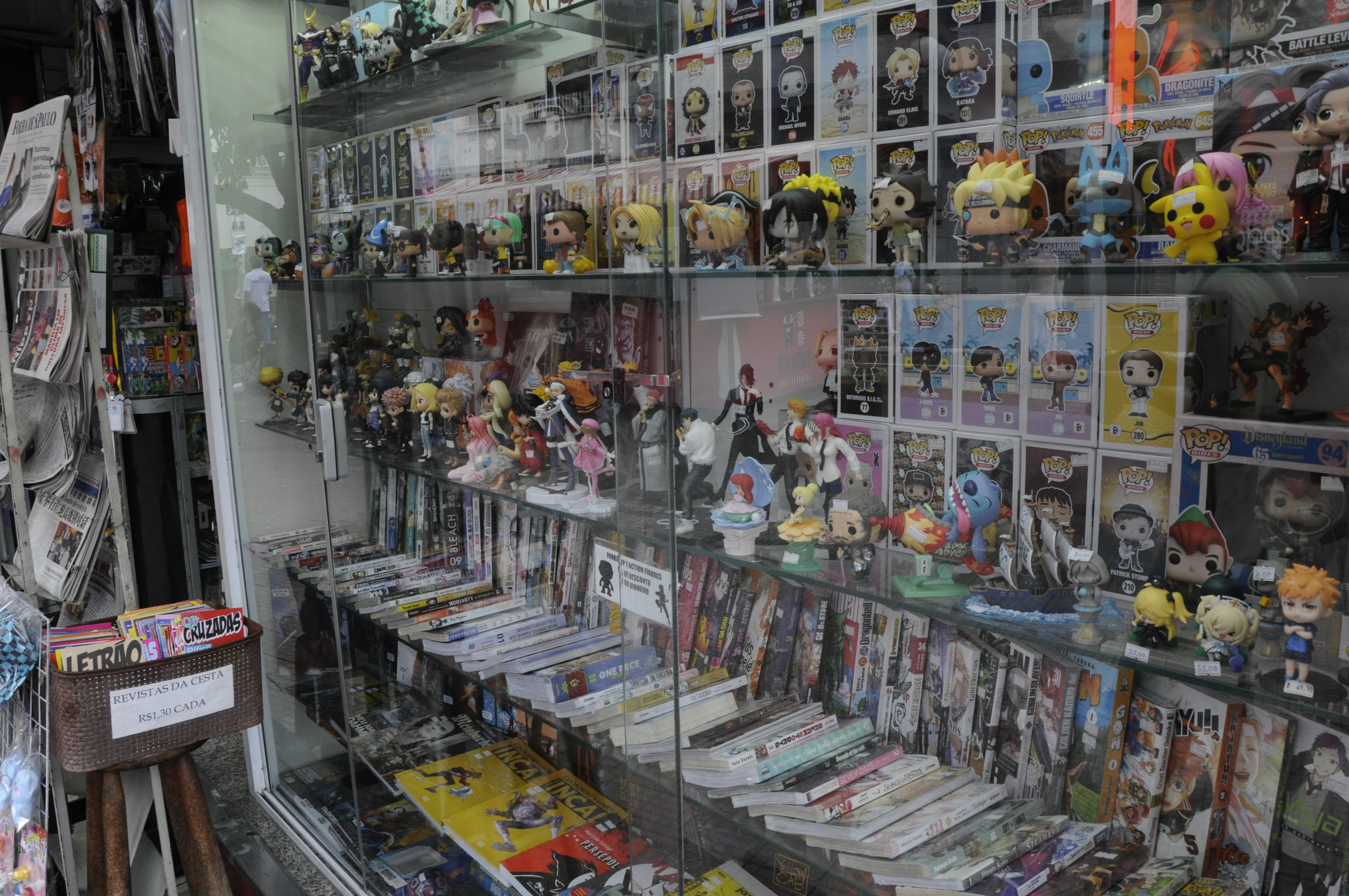 Produtos de animes e mangas sendo vendidos na banca de jornal ao lado do metrô. 