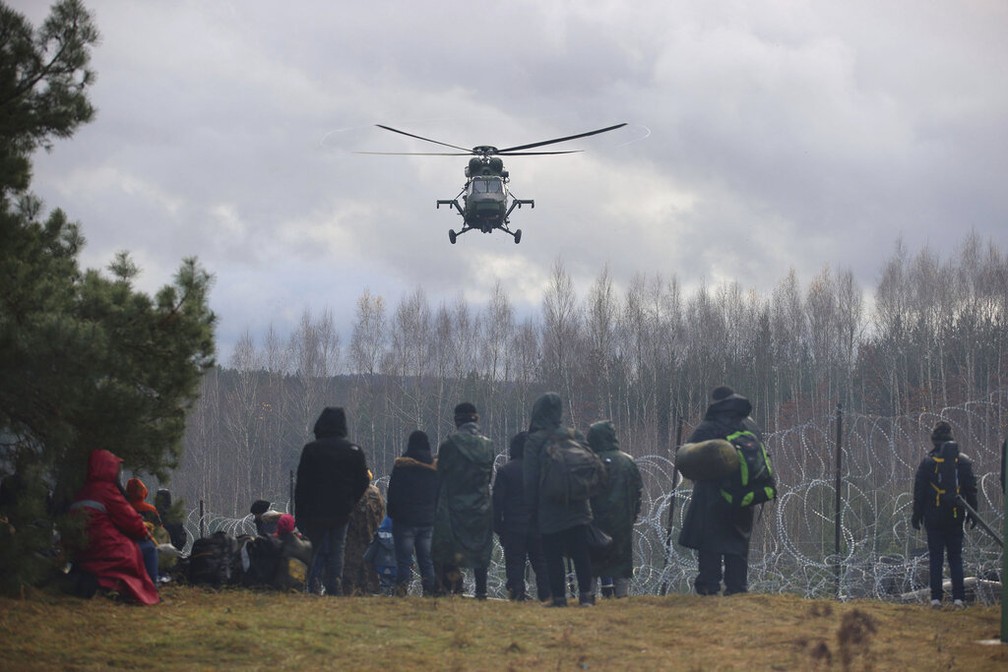 Helicóptero militar da Polônia vigia grupo de migrantes na fronteira com Belarus  — Foto: Leonid Shcheglov/BelTA via AP