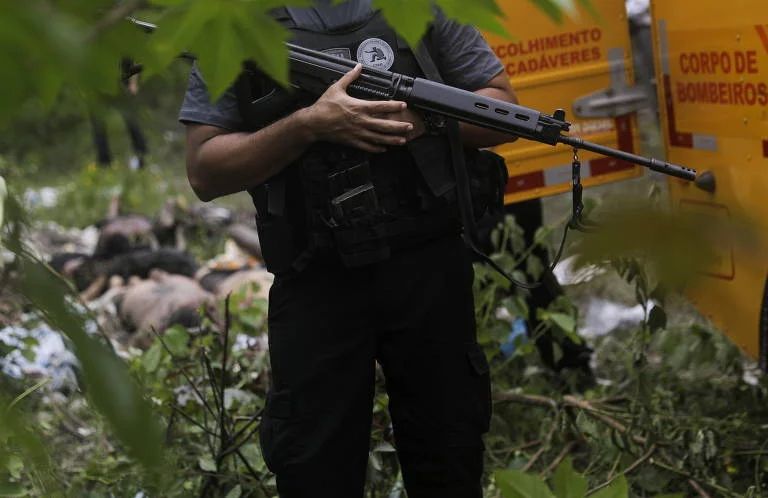 Policial próximo a corpos encontrados por moradores em área de mangue no Complexo do Salgueiro, em São Gonçalo, no Rio de Janeiro - Ricardo Moraes/Reuters