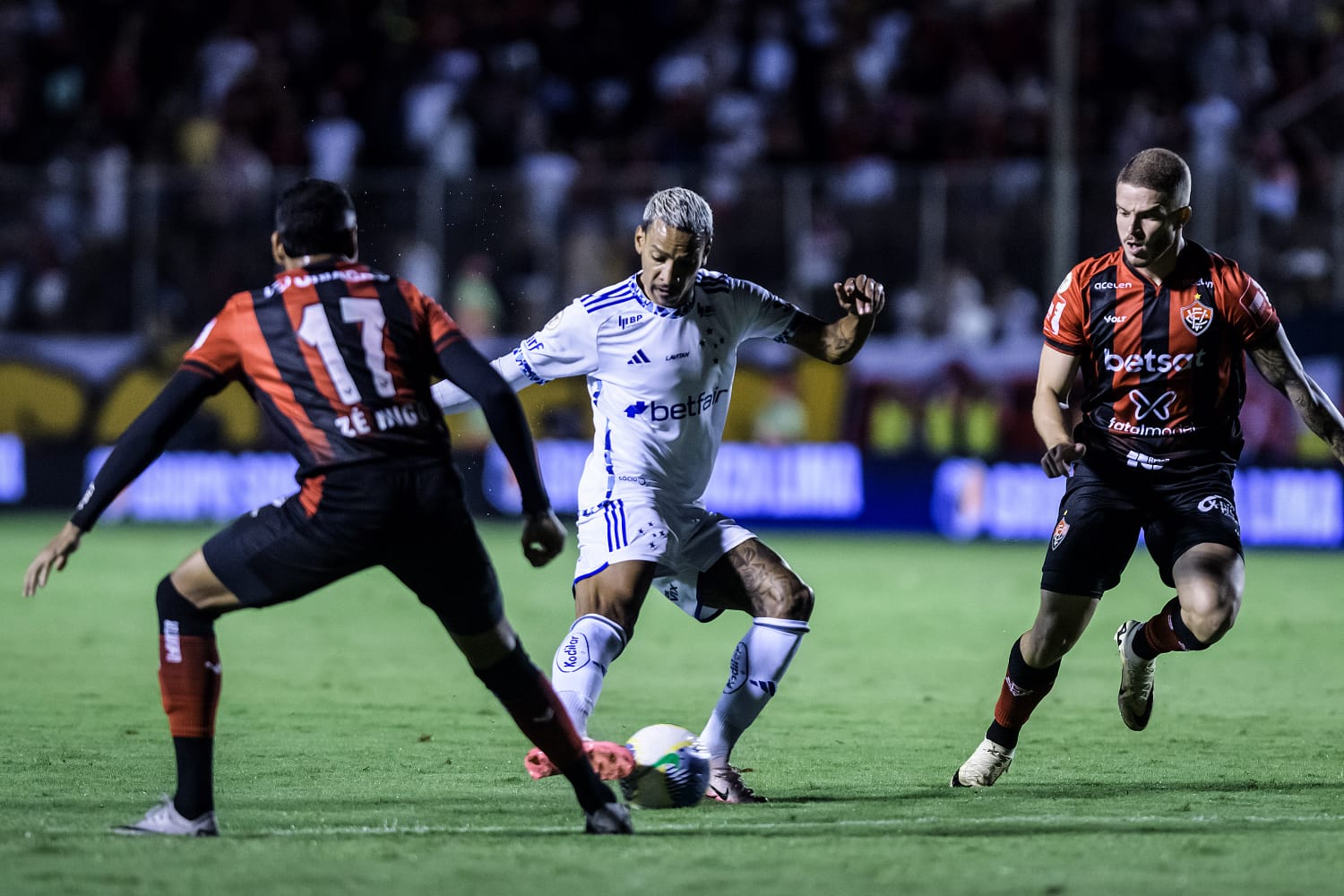 Matheus Pereira em disputa de bola com dois jogadores do Vitória. 