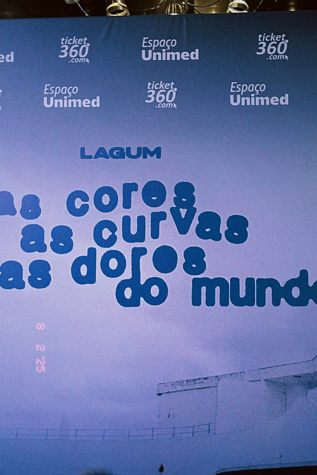 Painel fotográfico com a divulgação da turnê "As cores, as curvas e as dores do mundo" e patrocínios do show. 