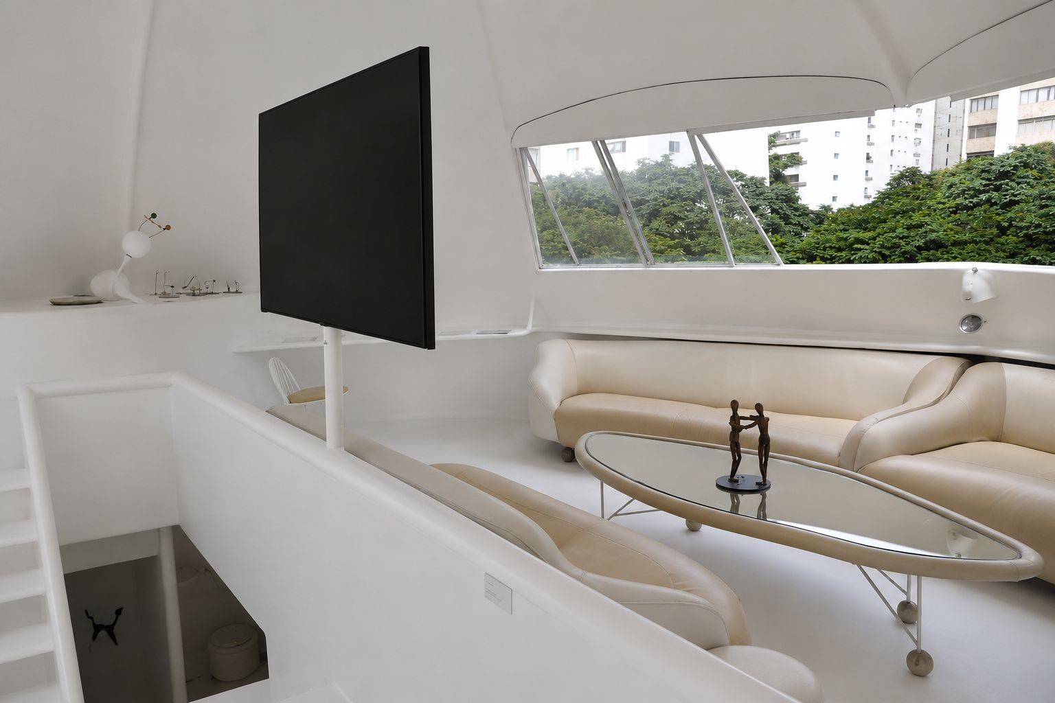Sala superior marcada por curvas contínuas e mobiliário integrado que reforçam a estética futurista.