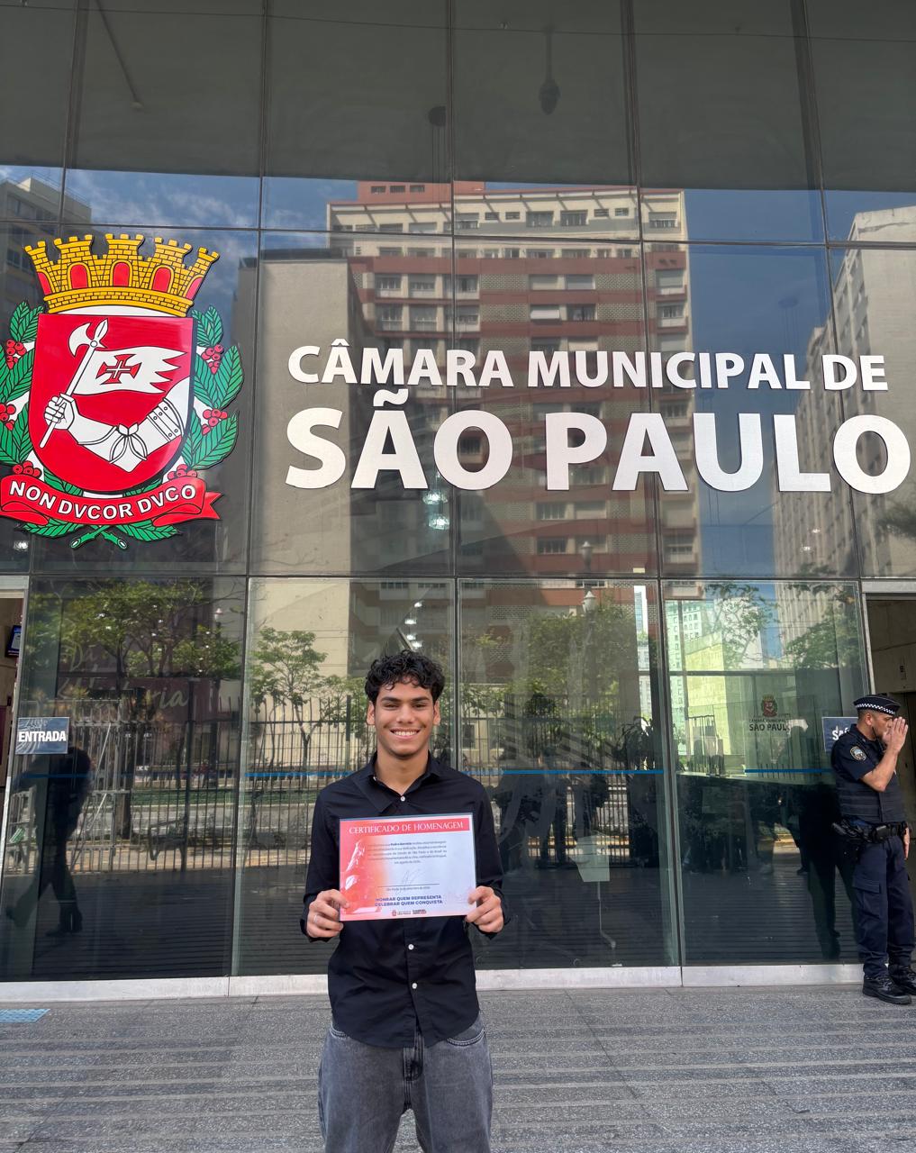Homem segura certificado em mãos.