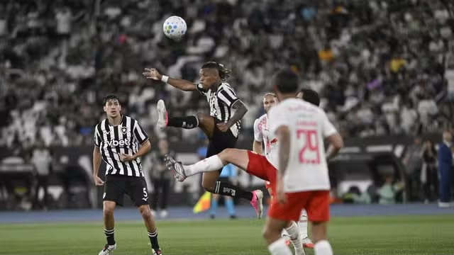 A imagem mostra uma disputa de bola das equipes